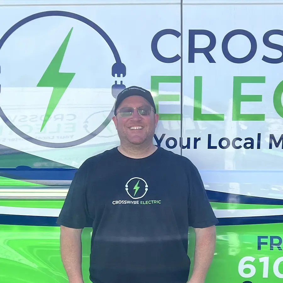 Crosswyre Electric owner standing in front of company van with logo, showcasing local electrical services.