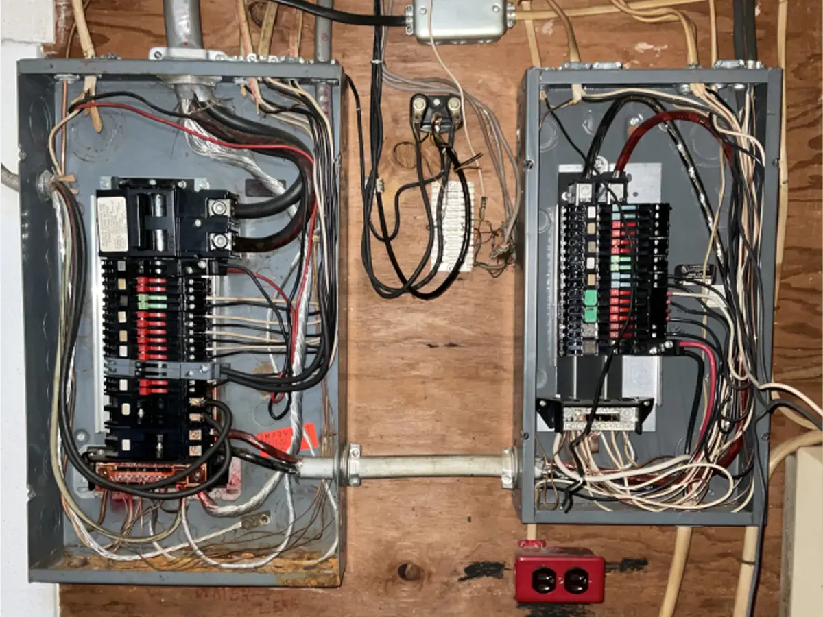 Dual electrical panels with wiring for residential breaker panel upgrade.